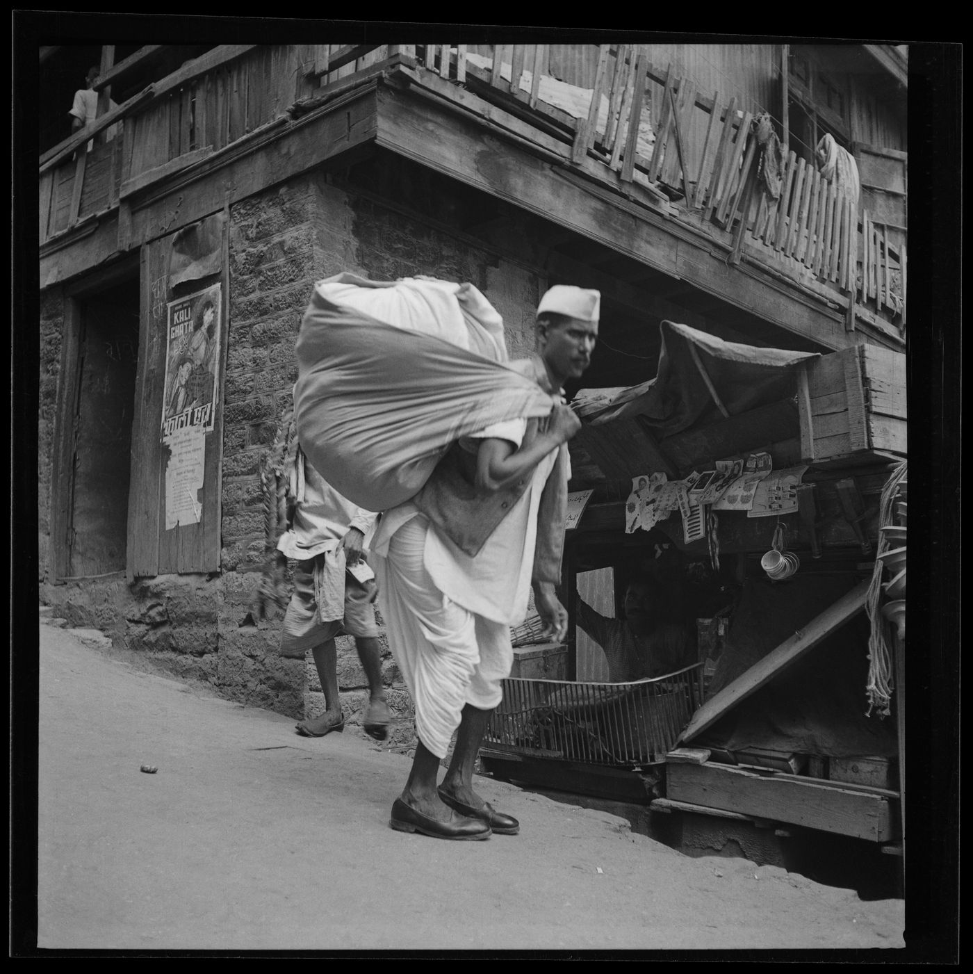 Unidentified man in front of urban building, India