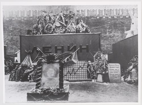View of the first wooden Lenin Mausoleum showing wreaths, flower arrangements, banners, and a tomb slab, Red Square, Moscow