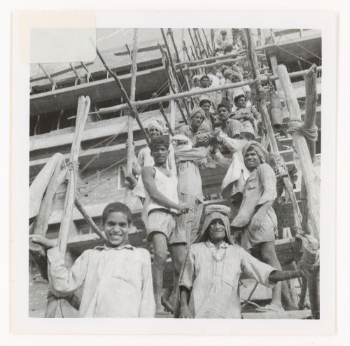 Portrait of construction workers passing on material supplies to upper levels of building, Chandigarh, India
