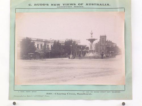 View of a fountain with stores and an office building [?] in the background, Charing Cross, Sandhurst, Australia