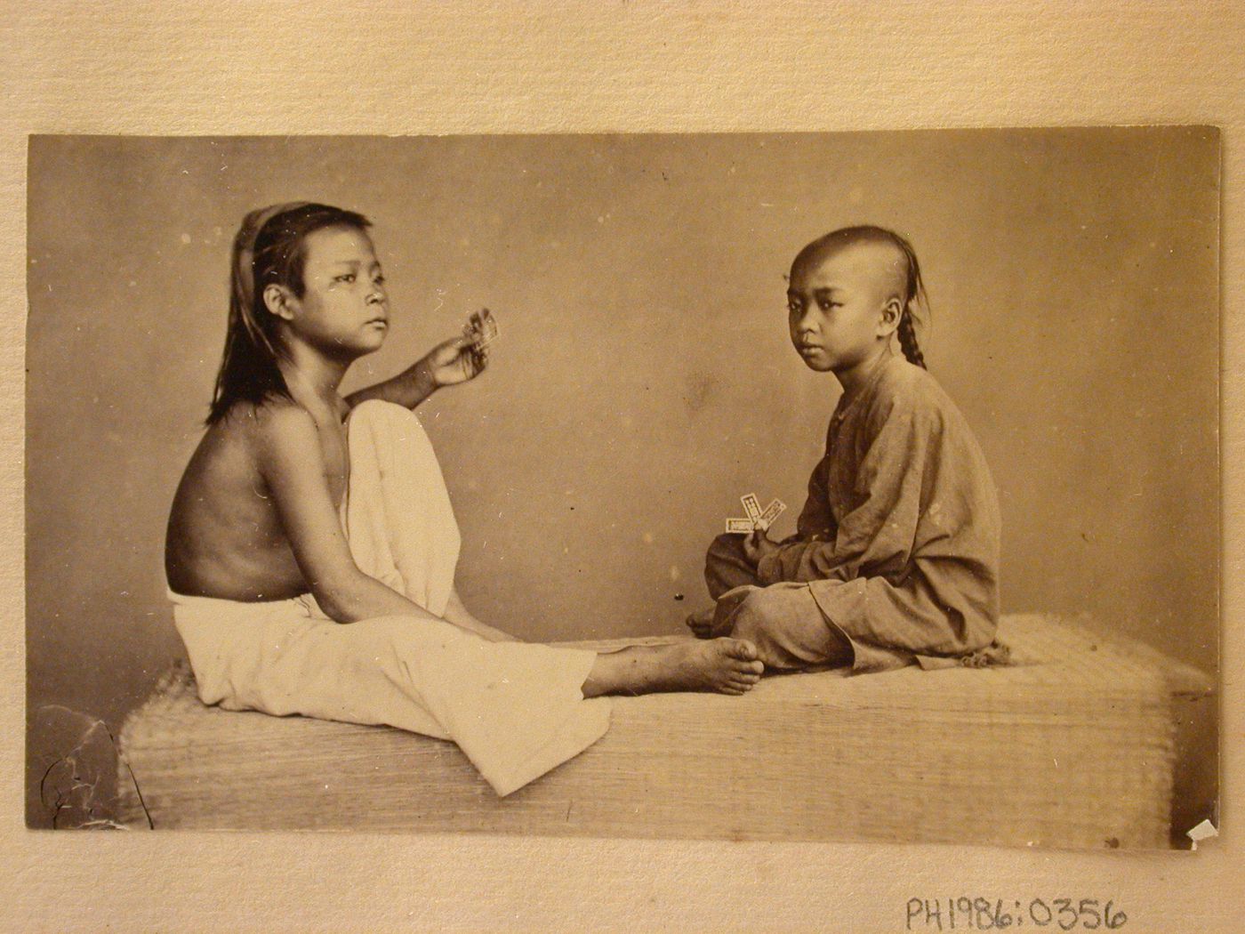Group portrait of two boys with playing cards, probably in Cochin China (now in Vietnam)