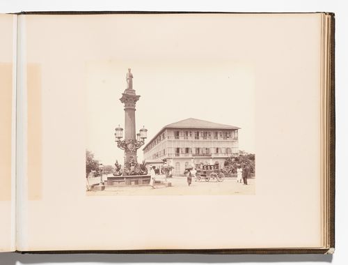 View of a column with the Statue of Cursetji Manekji (also known as the Khada Parsi) on top showing the Byculla Hotel in the background, Bombay (now Mumbai), India