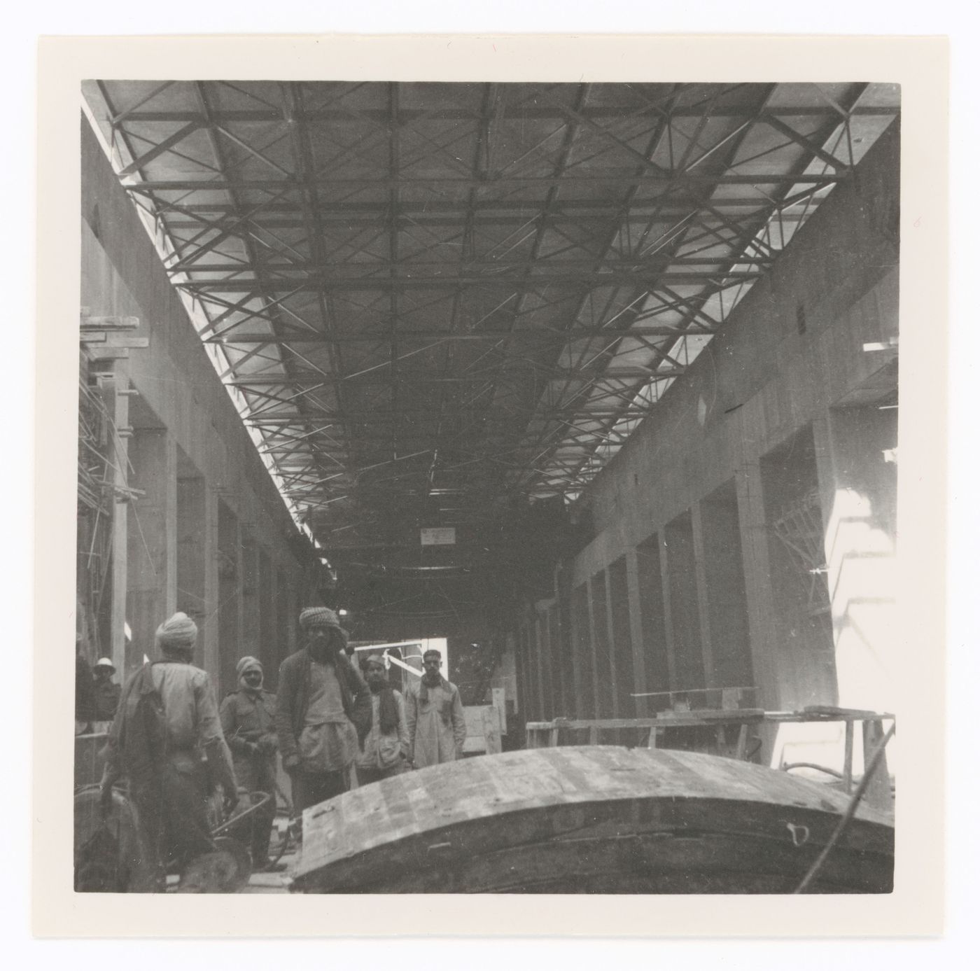 Interior view of an unidentified building under construction with workers, possibly in Chandigarh, India