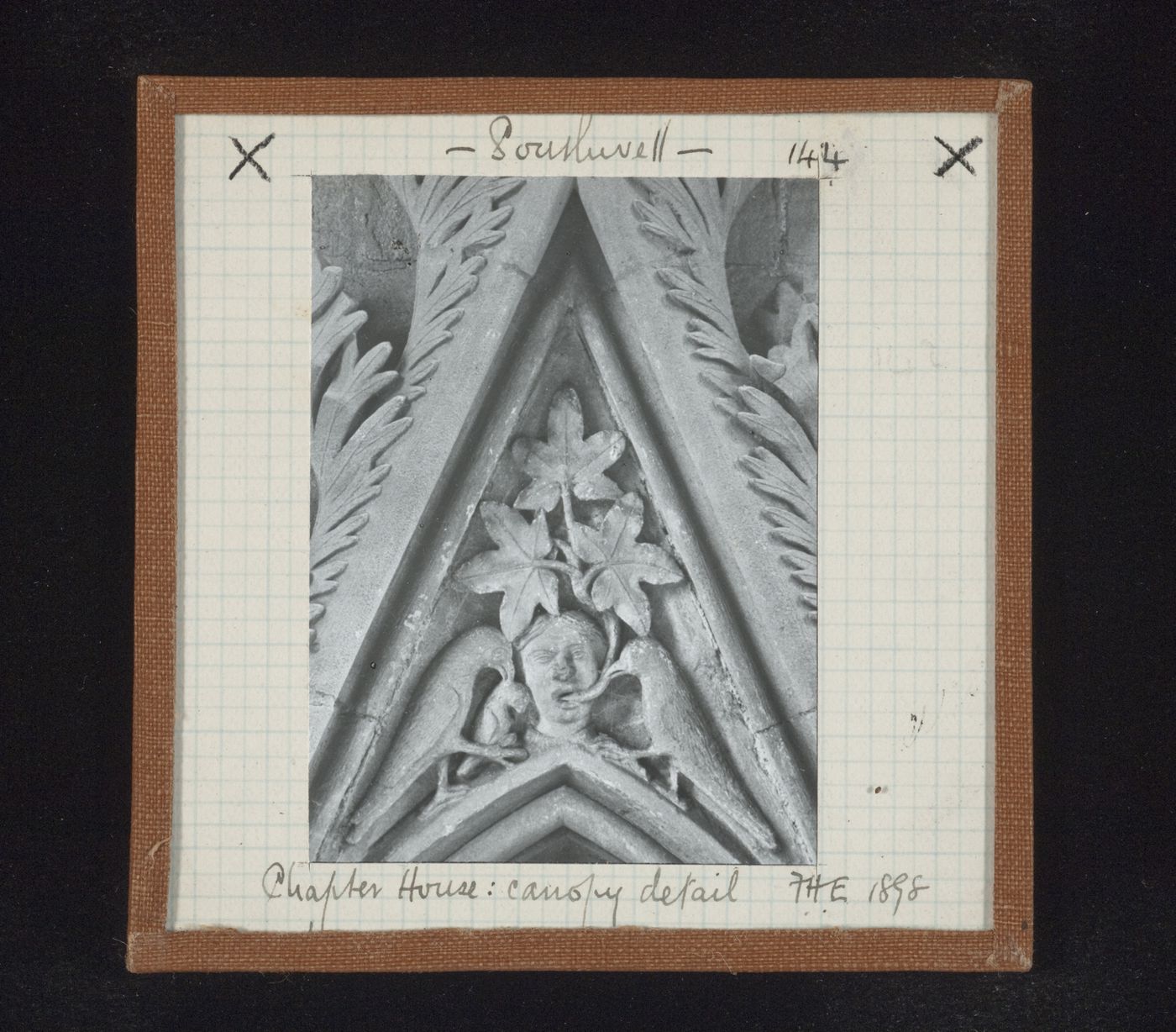Detail view of canopy with foliate mask and two birds on tympanum in Chapter House, Southwell Minster, Southwell, Nottinghamshire, England