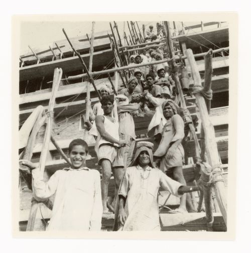 Portrait of construction workers passing on material supplies to upper levels of building, Chandigarh, India