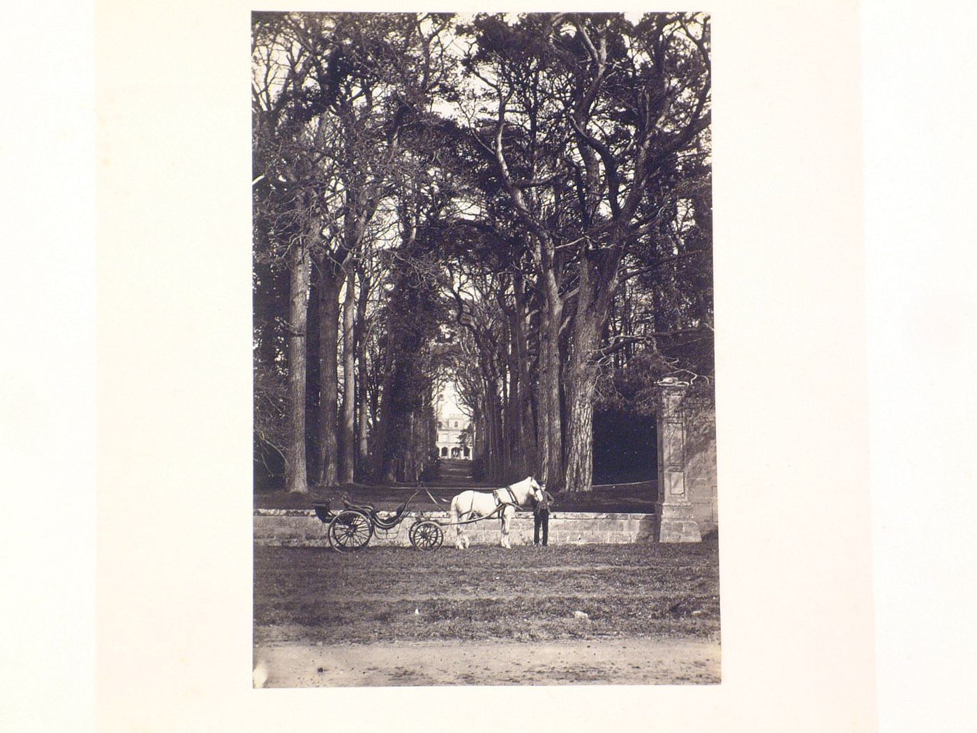View of a distant house, seen through an arcade of trees, with a carriage in the foreground, England ?