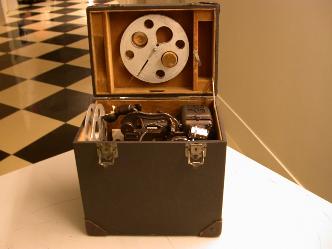 Projecteur de films, bobines (reels), ampoule et feuillet d'instructions dans leur boîtier