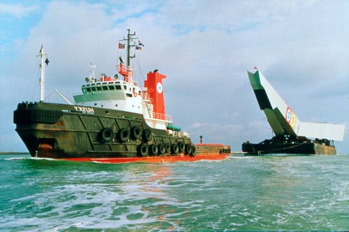 View of pylon being transported down the River Maas on a barge, Erasmus Bridge construction, Rotterdam