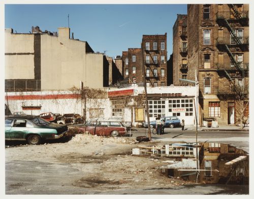 View of parking lot, gas station across street, children in street, New York City, New York