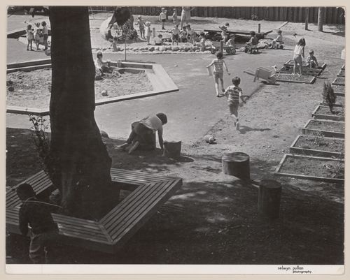 View of nature area showing sandbox, wheeltoy area, and garden beds of North Shore Neighbourhood House Playground, Vancouver, British Columbia