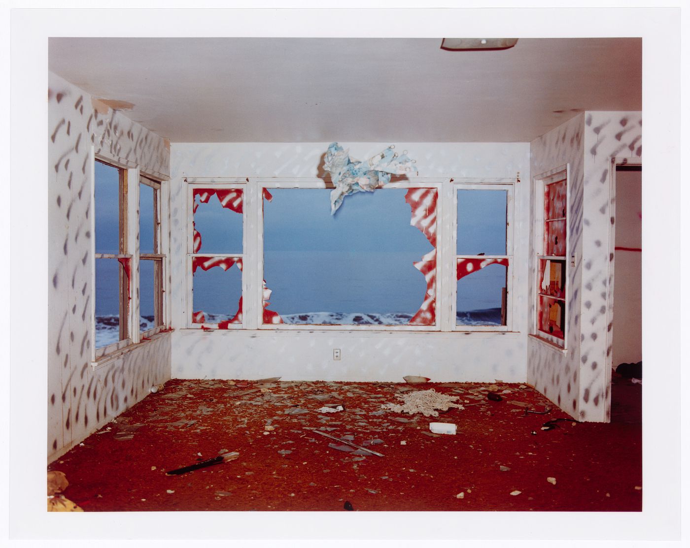 Abandoned beach house, room with orange carpet and silver graffittied walls, California ?