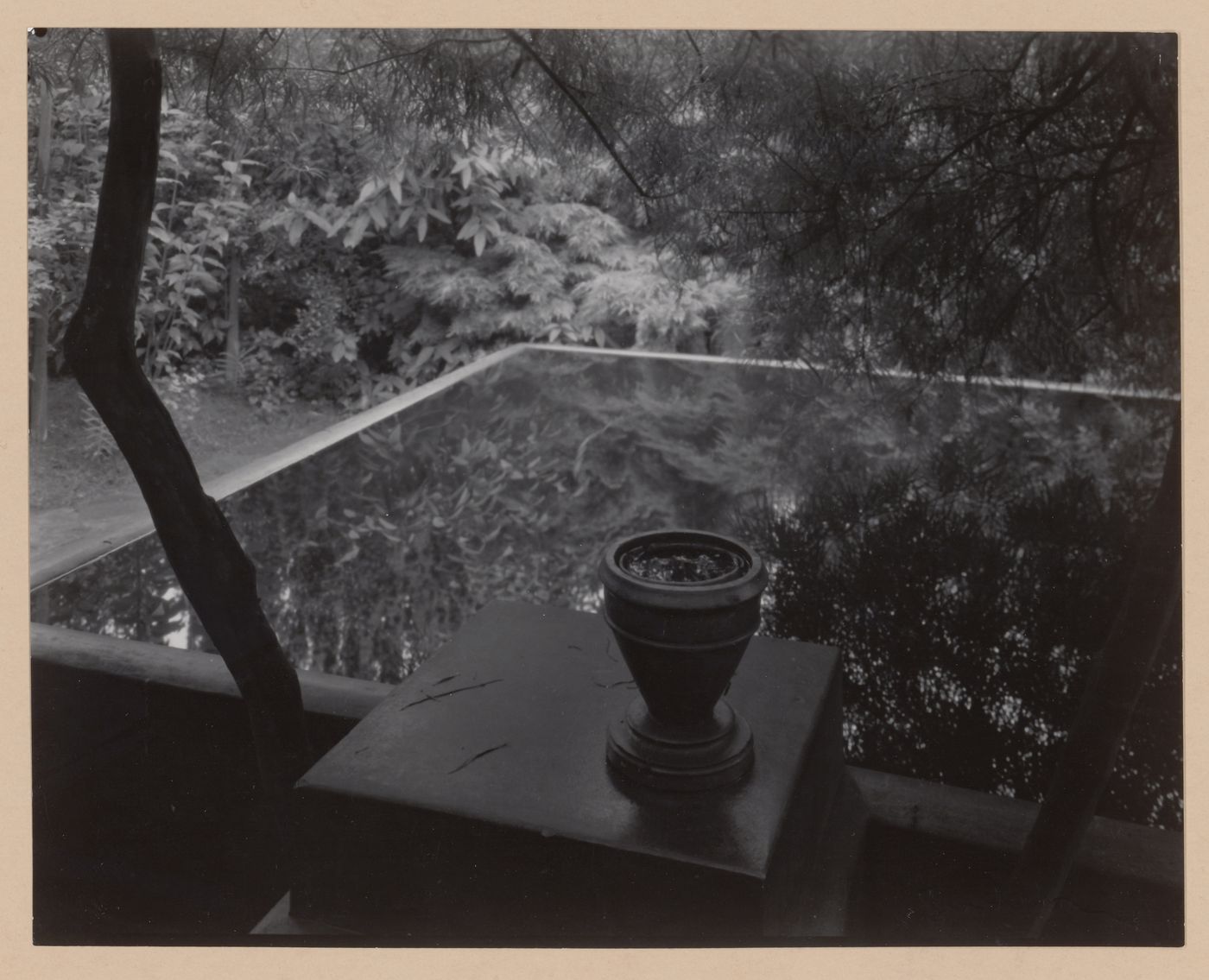 View of architect Otto Rothmayer's own garden showing urn next to water-filled basin reflecting surrounding foliage, Prague, Czechoslovakia