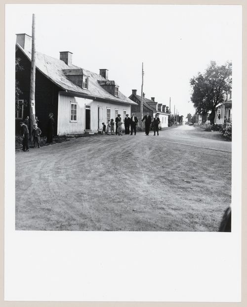 Rue d'un village, un dimanche matin, avec hommes et enfants dans leur habits du dimanche, Ile d'Orléans, Québec