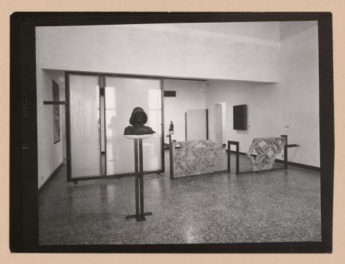 Interior view of a gallery showing a bust on a pedestal and fragments of stone tracery, Museo Correr, Venice, Italy