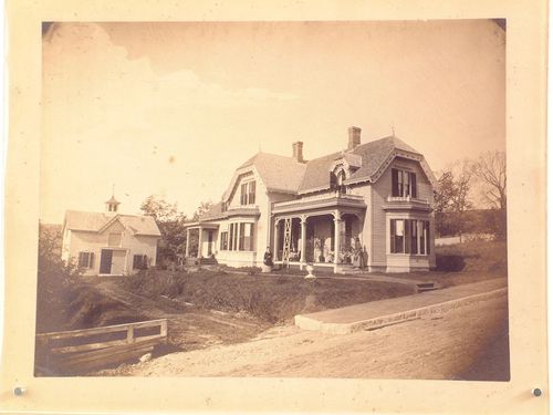 Victorian house and carriage barn, with three women outside