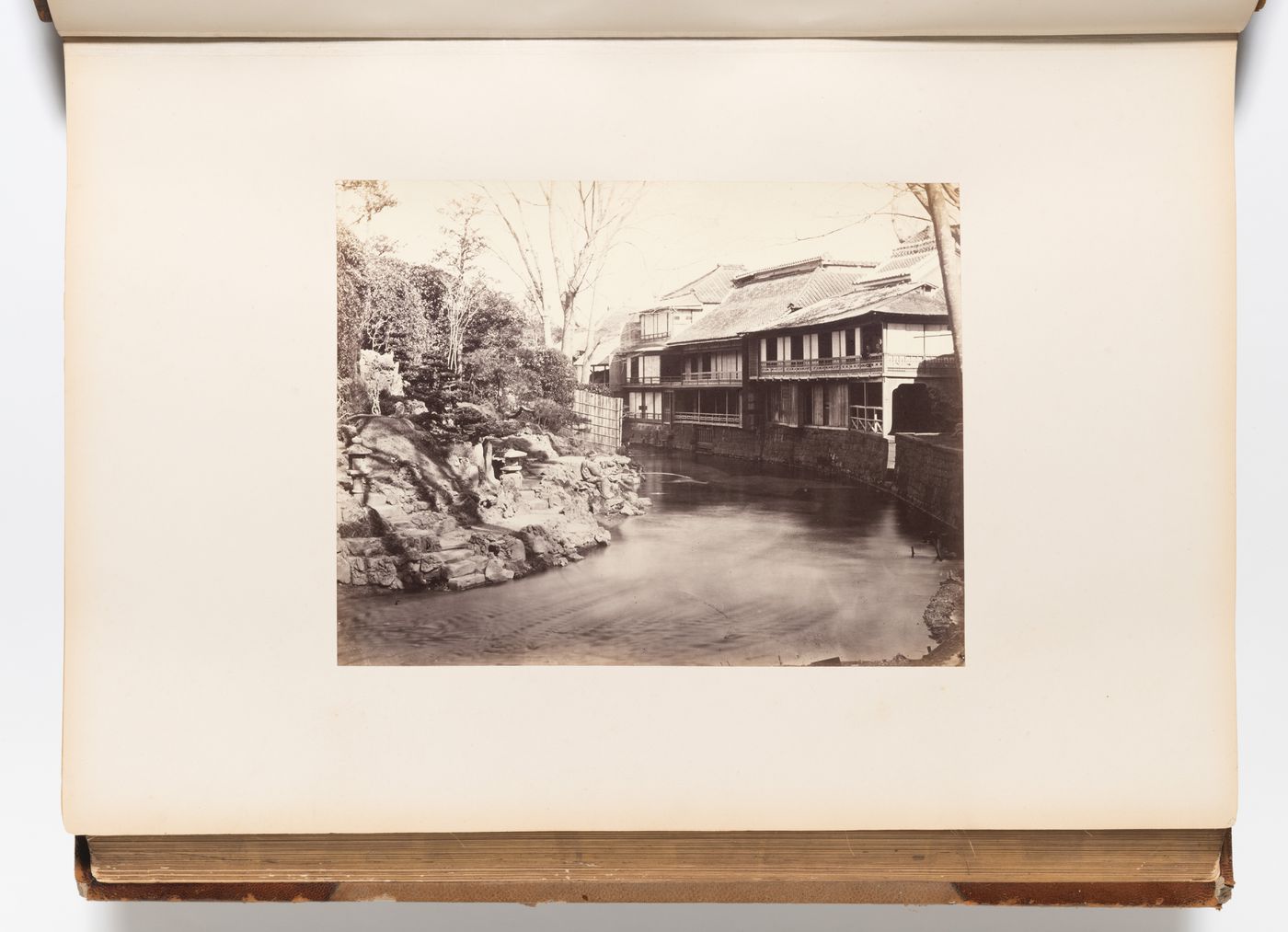View of the Ogiya public teahouse and other buildings on the Shakujii (also known as the Otonashi) River with fisherman, Oji district, Edo (now Tokyo), Japan