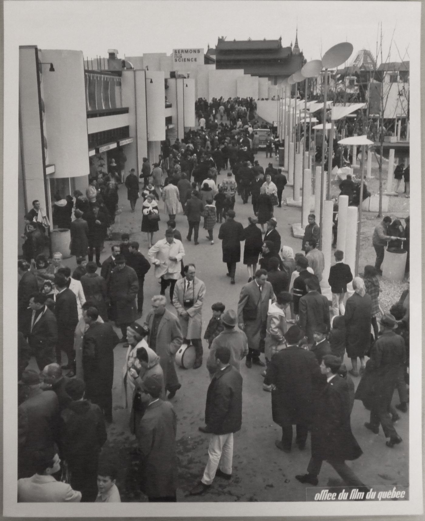 View of the walkway of the Expo-Service C with the Sermons from Science Pavilion in background, Expo 67, Montréal, Québec