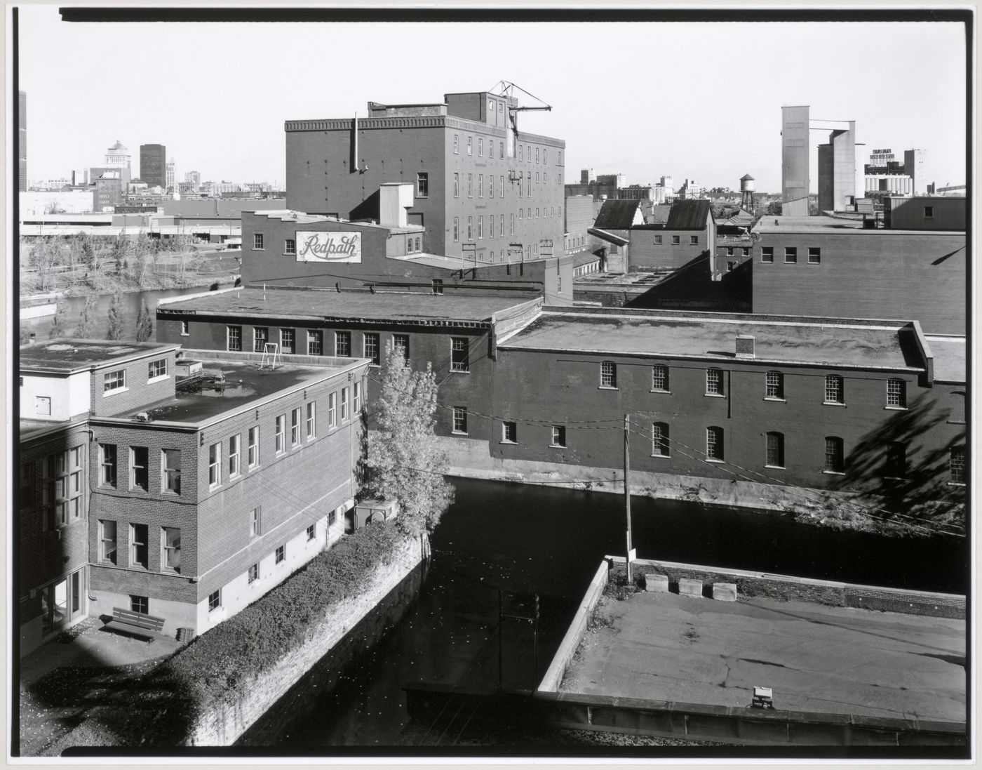 View of the Redpath Sugar Refinery looking east from the roof of the Belding Corticelli Spinning Mill with Lachine Canal and downtown Montréal in the background, Montréal, Québec