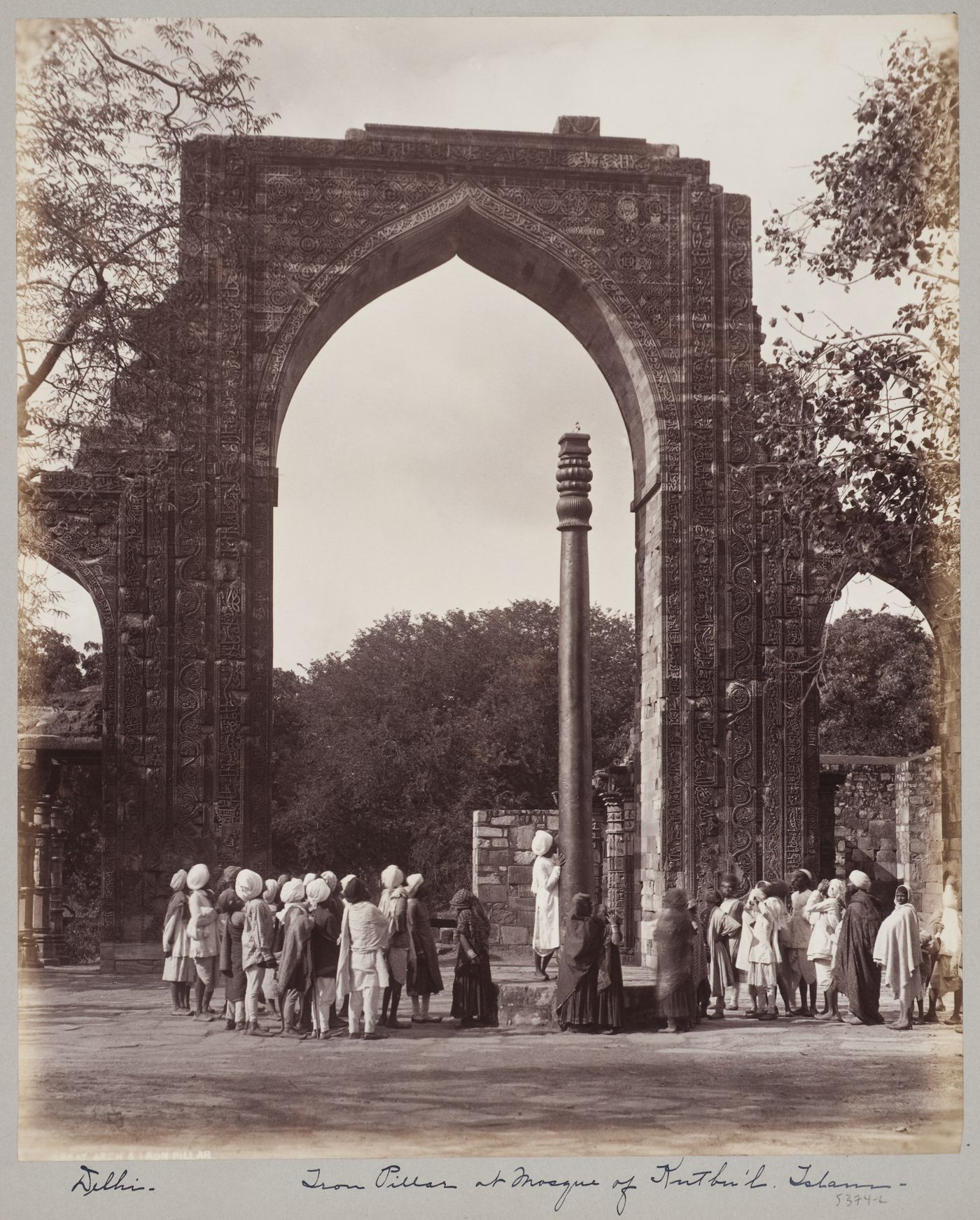 View of the arched screen façade of the Quwwat al-Islam [Might of Islam] Mosque and the Iron Pillar, Quwwat al-Islam Mosque Complex, Delhi, India