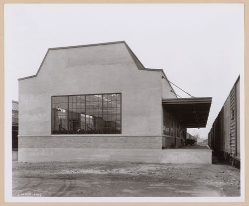 View of the principal and lateral façades of the Paint Mixing and Storage Building with the loading dock and a train on the right, General Motors Corporation Chevrolet division Commercial Body Plant, Indianapolis, Indiana