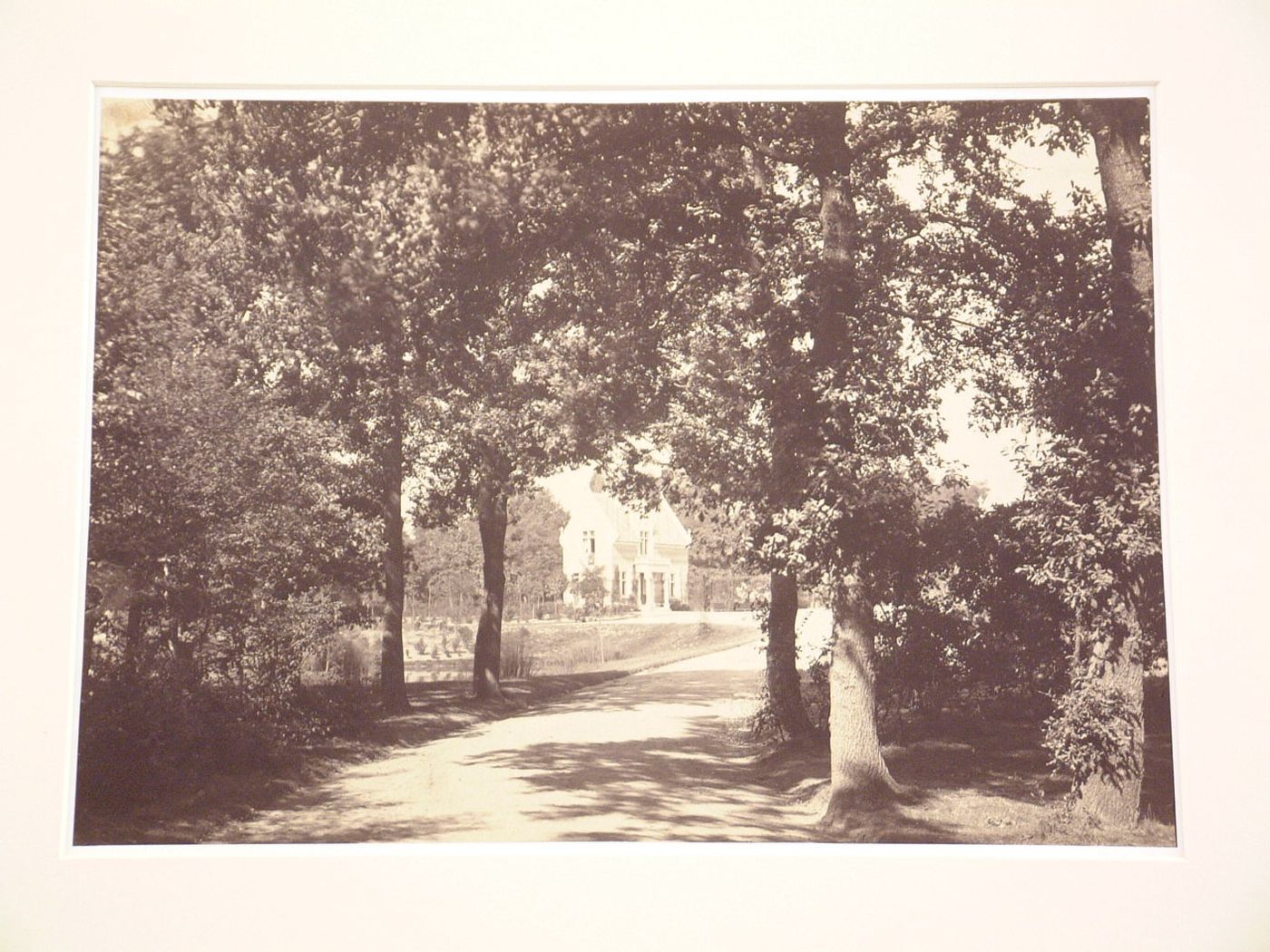 Distant view of unidentified gate house, one trees and road in foreground, Bois de Boulogne, Paris, France
