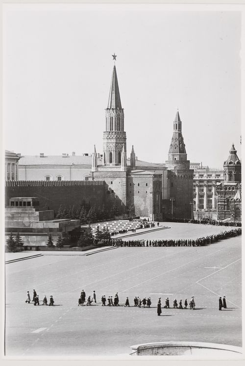 View of the stone Lenin Mausoleum showing people waiting to enter the mausoleum and the Nikol'skaia Tower (Nicholas Tower) and Corner Arsenal Tower in the background, Red Square, Moscow