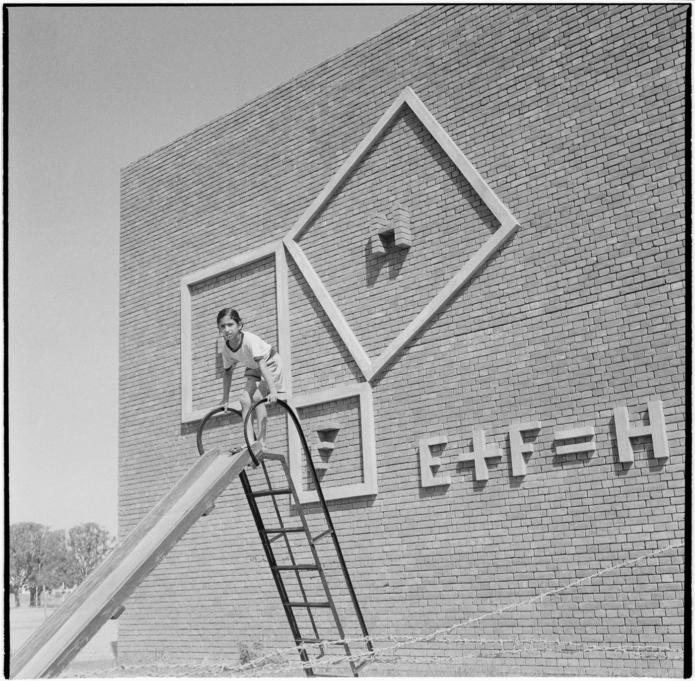 Girl on a slide in front of the Junior Secondary School-II, Sector 22, Chandigarh, India