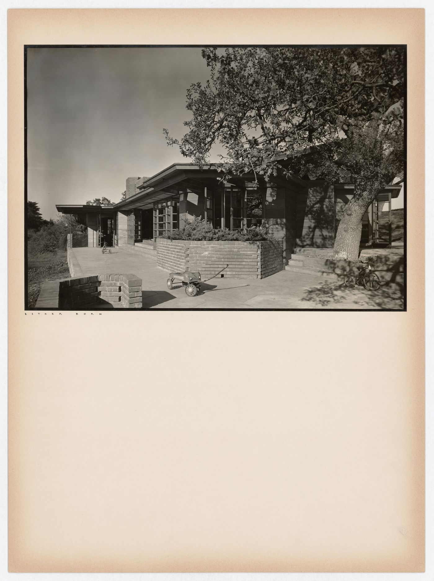 View of the Hanna House showing a terrace, entrances, a tree, a toy wagon, and a tricycle, Palo Alto, California, United States