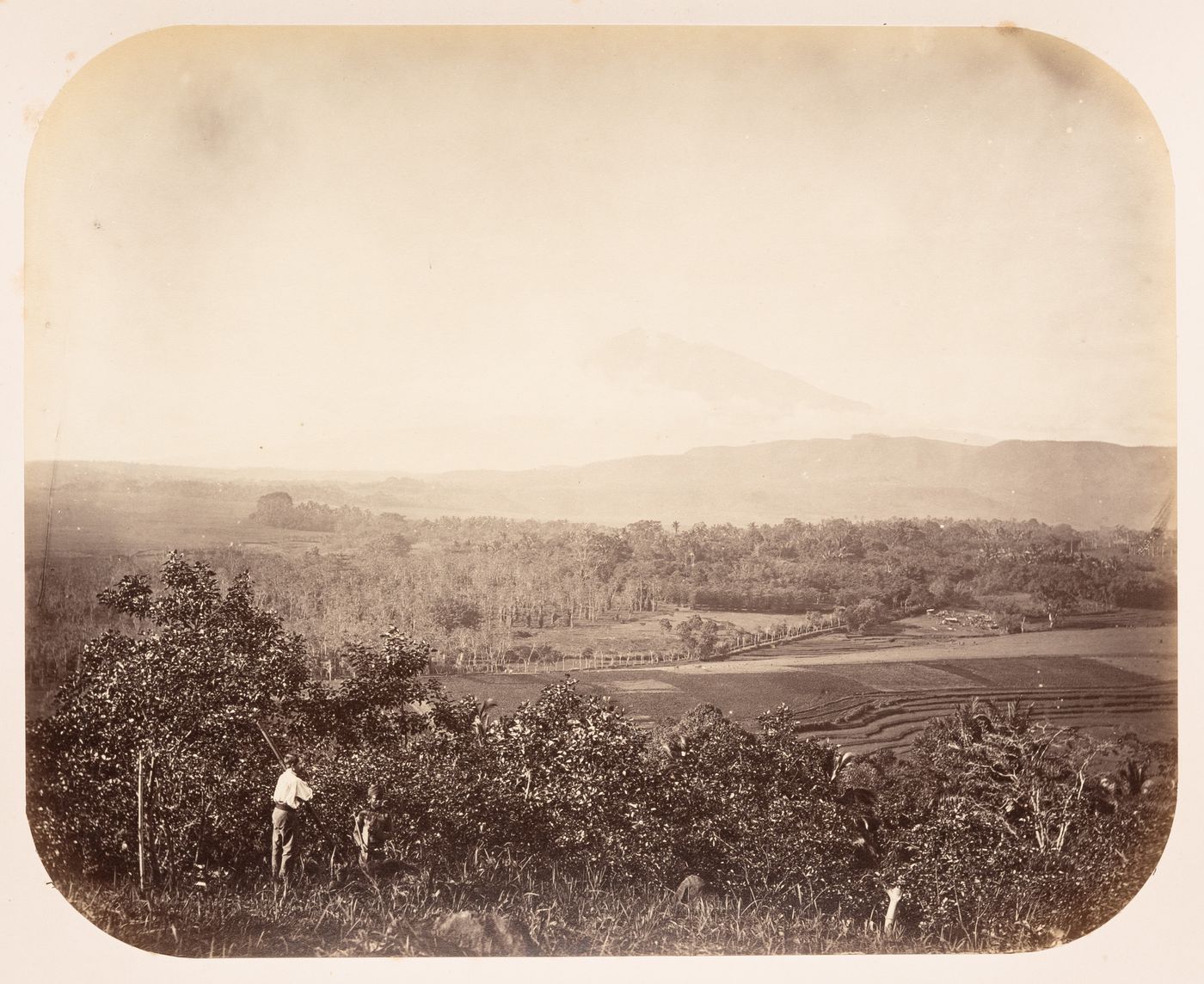 View of the countryside between Semarang and Solo (now also known as Surakarta) showing a valley and a volcano, Dutch East Indies (now Indonesia)