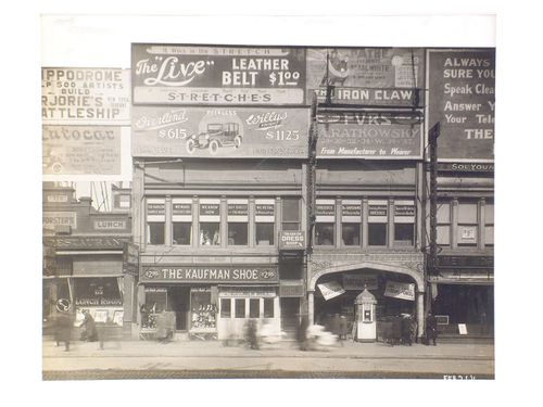 Billboards on 125th Street between Lenox Avenue and Seventh Avenue, Harlem, New York City: The Kaufman Shoe, The Harlem Dress shop, Pathé Theatre (‘The Iron Claw’), Peerless Motors, Hippodrome Theatre.