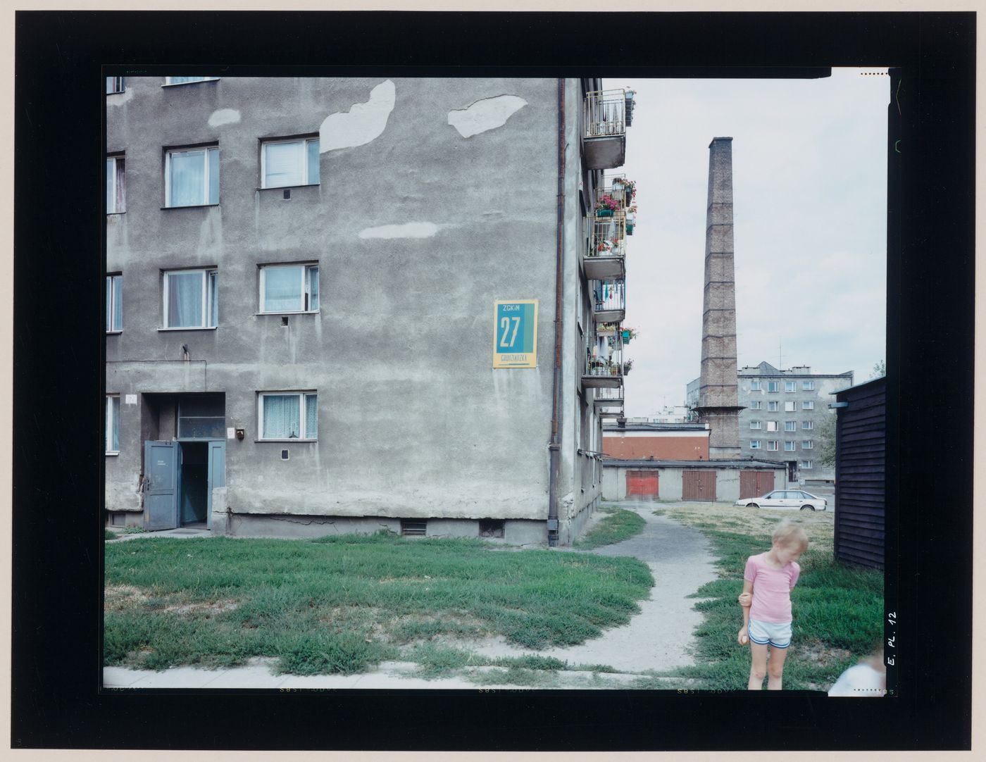 View of apartment houses, a child and a smokestack, Elblag, Poland (from the series "In between cities")