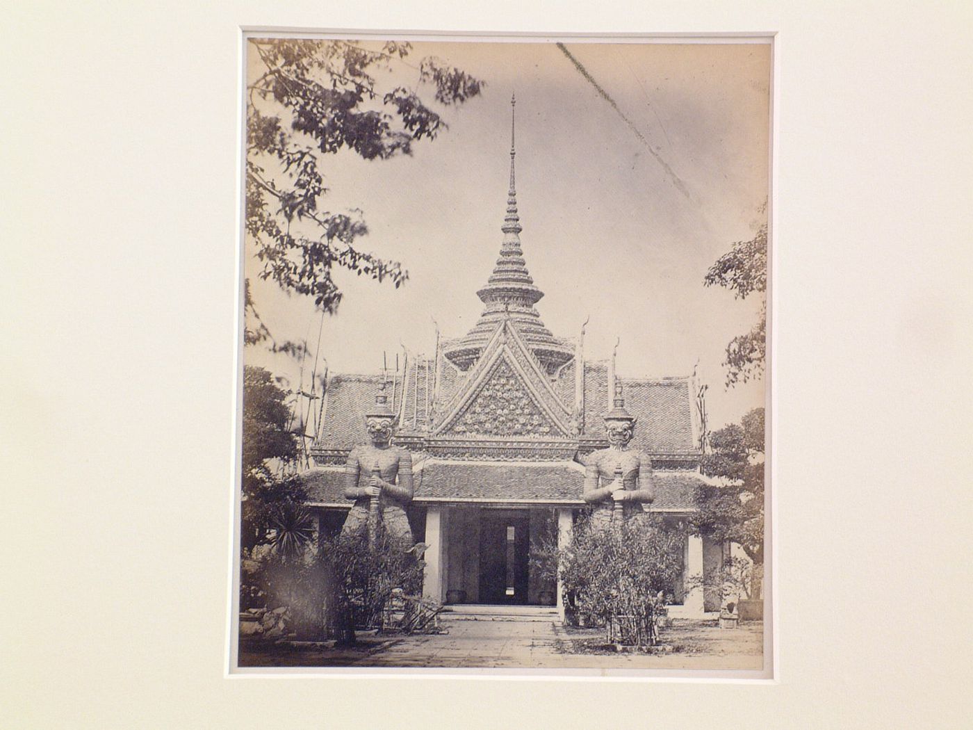 View of the entrance to Phra Thinang Amarin Winichai (also known as the Audience Hall of Amarindra Vinitchai) showing a stupa and two guardian demon statues, Phraborommamaharatchawang (also known as the Grand Palace) complex, Bangkok, Siam (now Thailand)