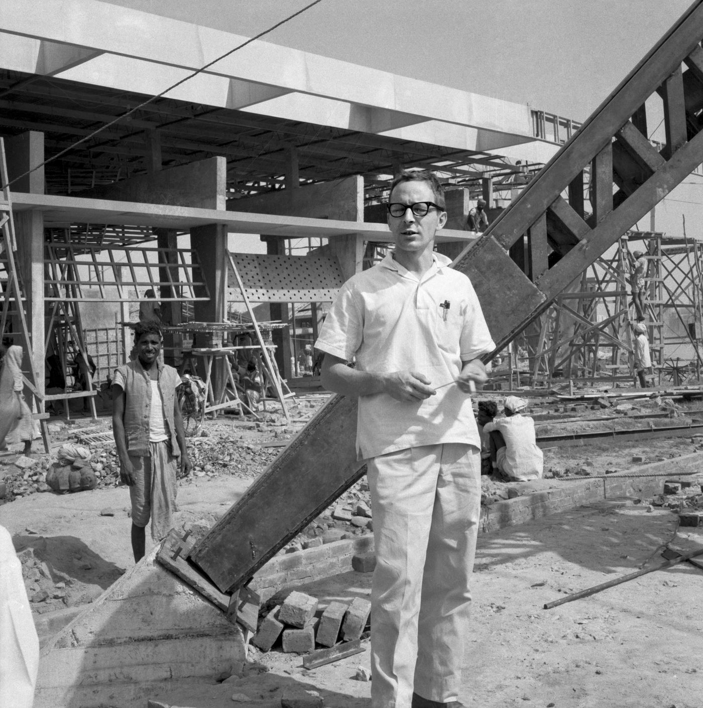 Portrait de Luc Durand devant le Pavilion for Air India International en construction, Indian Industries Fair, New Delhi, Inde