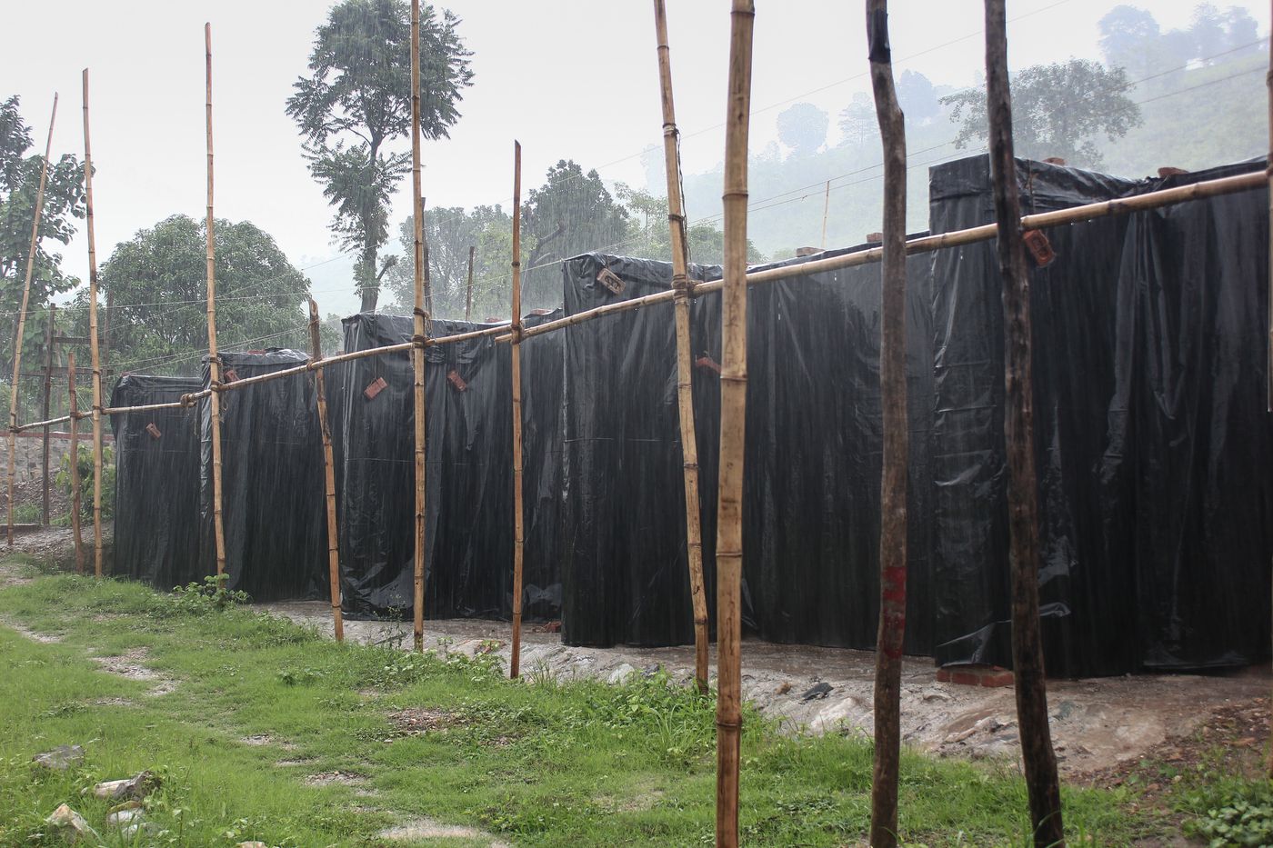 Weavers' Studio : workshop building under construction protected with plastic sheets during monsoon