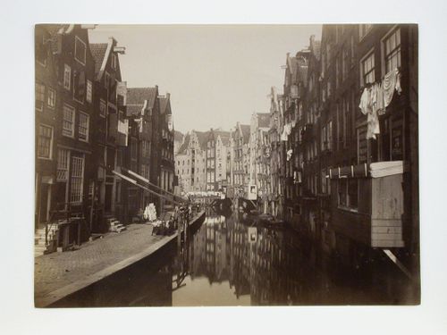 View, probable from a bridge down a narrow canal with houses on each side, Amsterdam, Netherlands