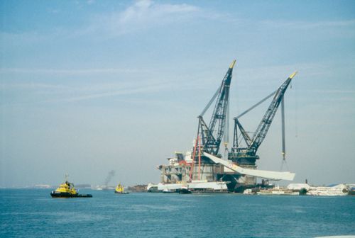 View of pylon being lifted onto heels, in preparation for final transportation to the site, Erasmus Bridge construction, Rotterdam
