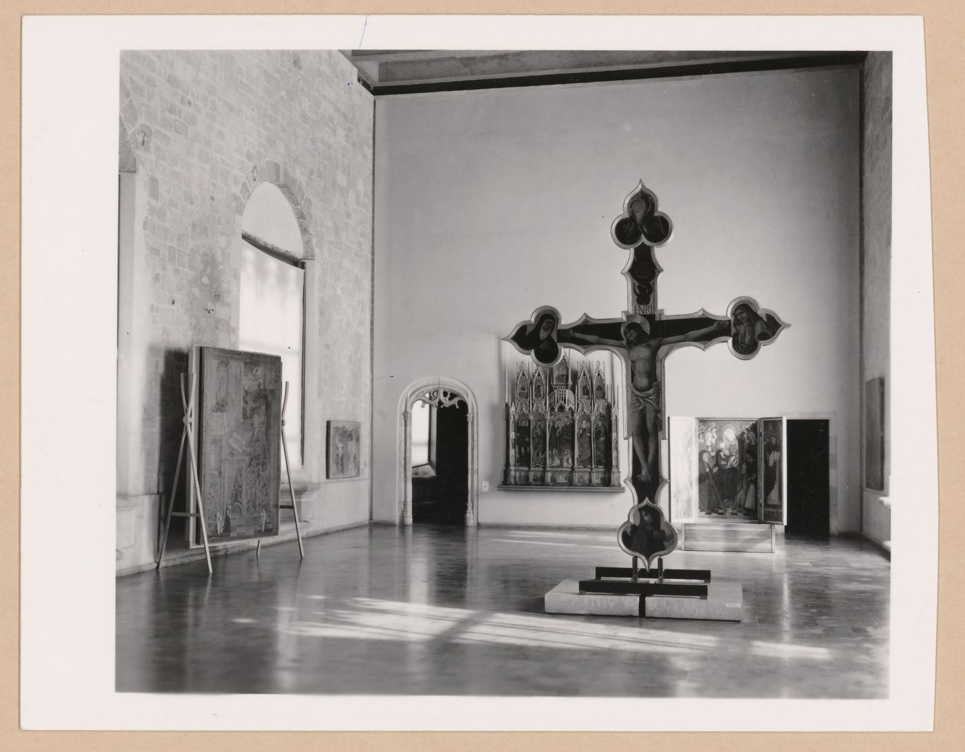 Interior view of a gallery showing a freestanding painted crucifix and paintings, Palazzo Abatellis, Galleria regionale della Sicilia, Palermo, Italy
