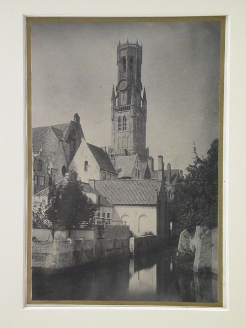 View of canal, houses, and church tower, Bruges, Belgium