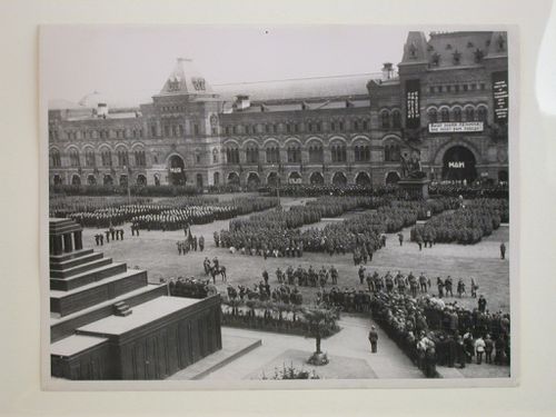 View of a May Day parade in Red Square with the second wooden Lenin Mausoleum in the foreground and the Upper Shopping Arcades and monument to Minin and Pozharsky in the background, Moscow