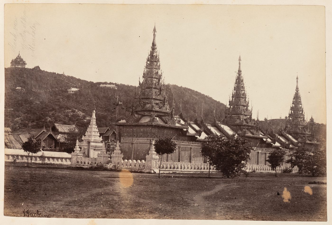 View of the pyatthats and a gateway of a monastery with Manadalay Hill in the background, Mandalay, Burma (now Myanmar)