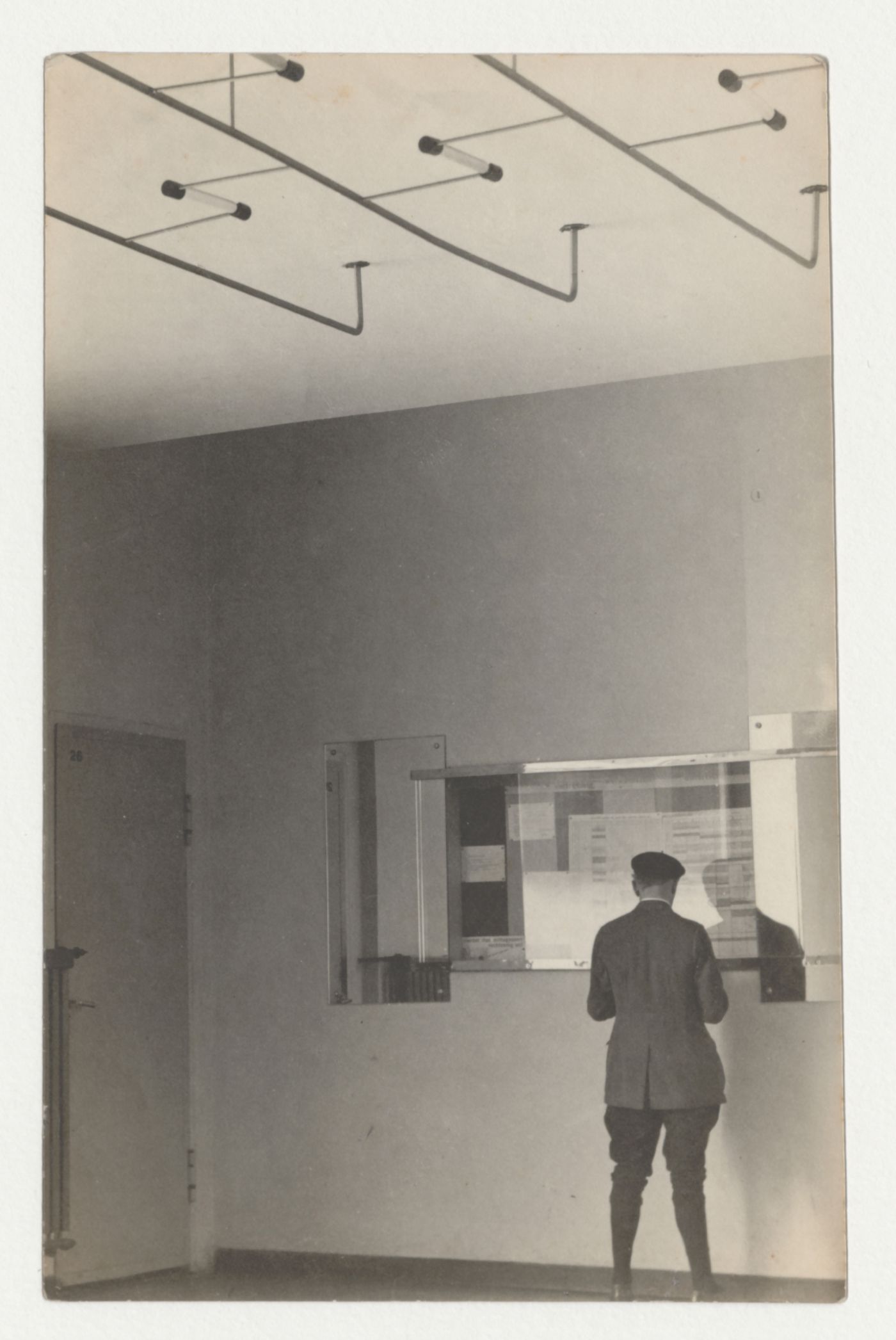 Interior view of Van Nelle Factory showing a man consulting a bulletin board, Rotterdam, Netherlands