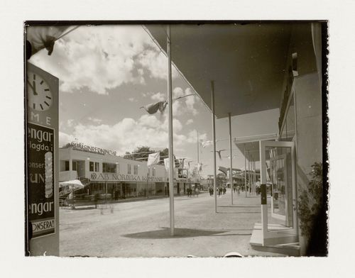 View of the principal façade of hall 8 at the Stockholm Exhibition of 1930 showing a covered walkway with an advertising post in the foreground, Stockholm