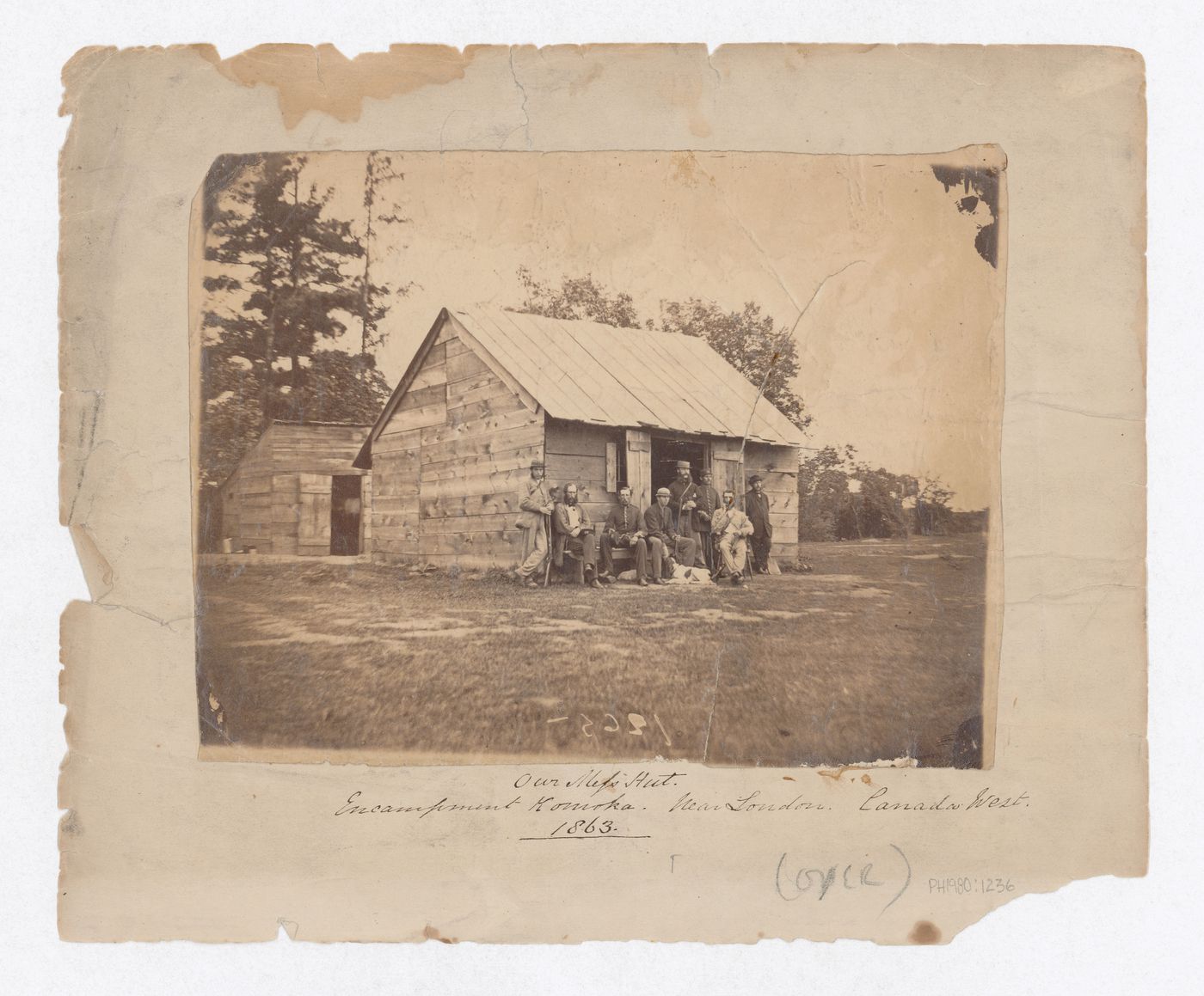 Portrait of a group of soldiers [?] posing outside the Mess Hut of the Komoka encampment, Komoka, Canada (now Komoka, Ontario, Canada)