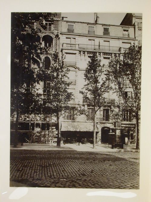 View across a street looking towards a café, apartment houses, a pissoir and a building site, Paris, France