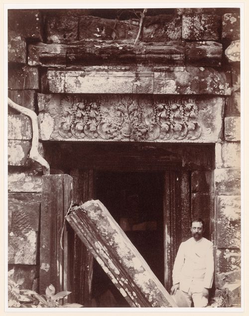 Portrait of a man standing beside the ruins of a temple, probably in Angkor, Siam (now in Cambodia)