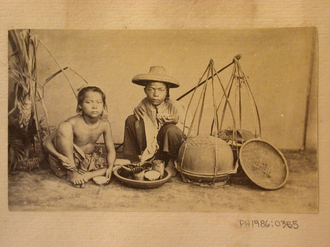 Group portrait of two boys with baskets, probably in Cochin China (now in Vietnam)