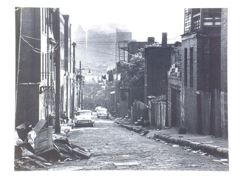 Looking down cobble-stone residential street, clothes-lines strung across, Pittsburgh, Pennsylvania