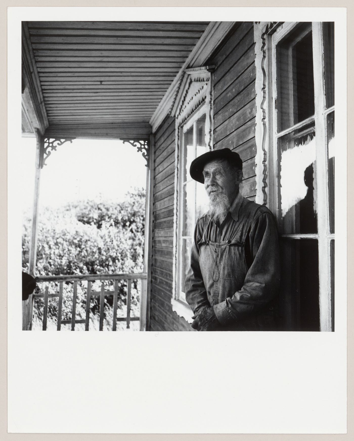 Portrait de l'artisan Servule Morneau sur le portique de sa maison, Saint-Jean-Port-Joli, Québec