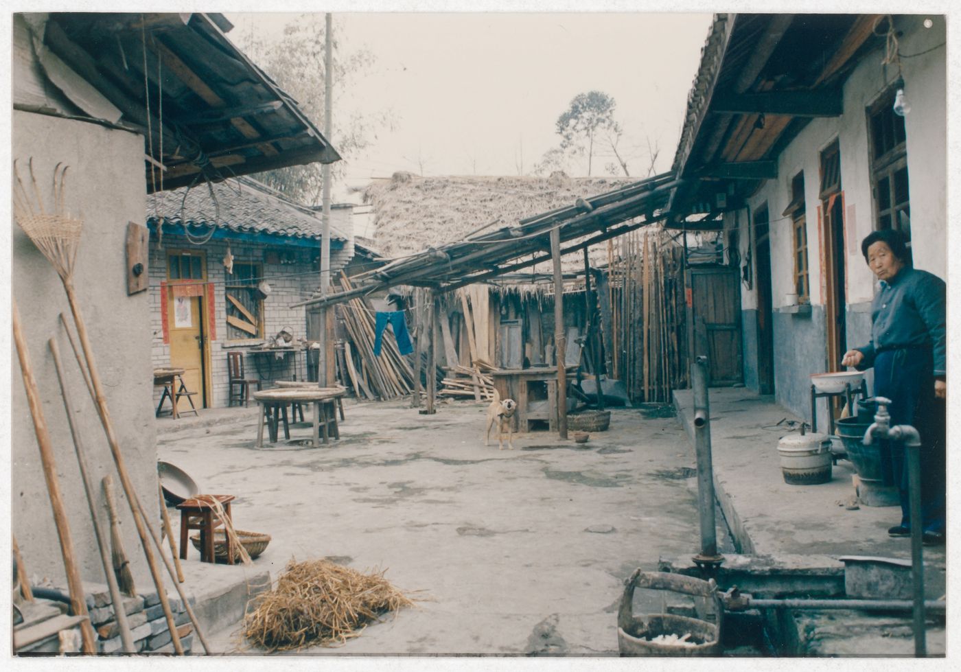 View of rural house interior court with a resident and a dog in Sichuan province, China