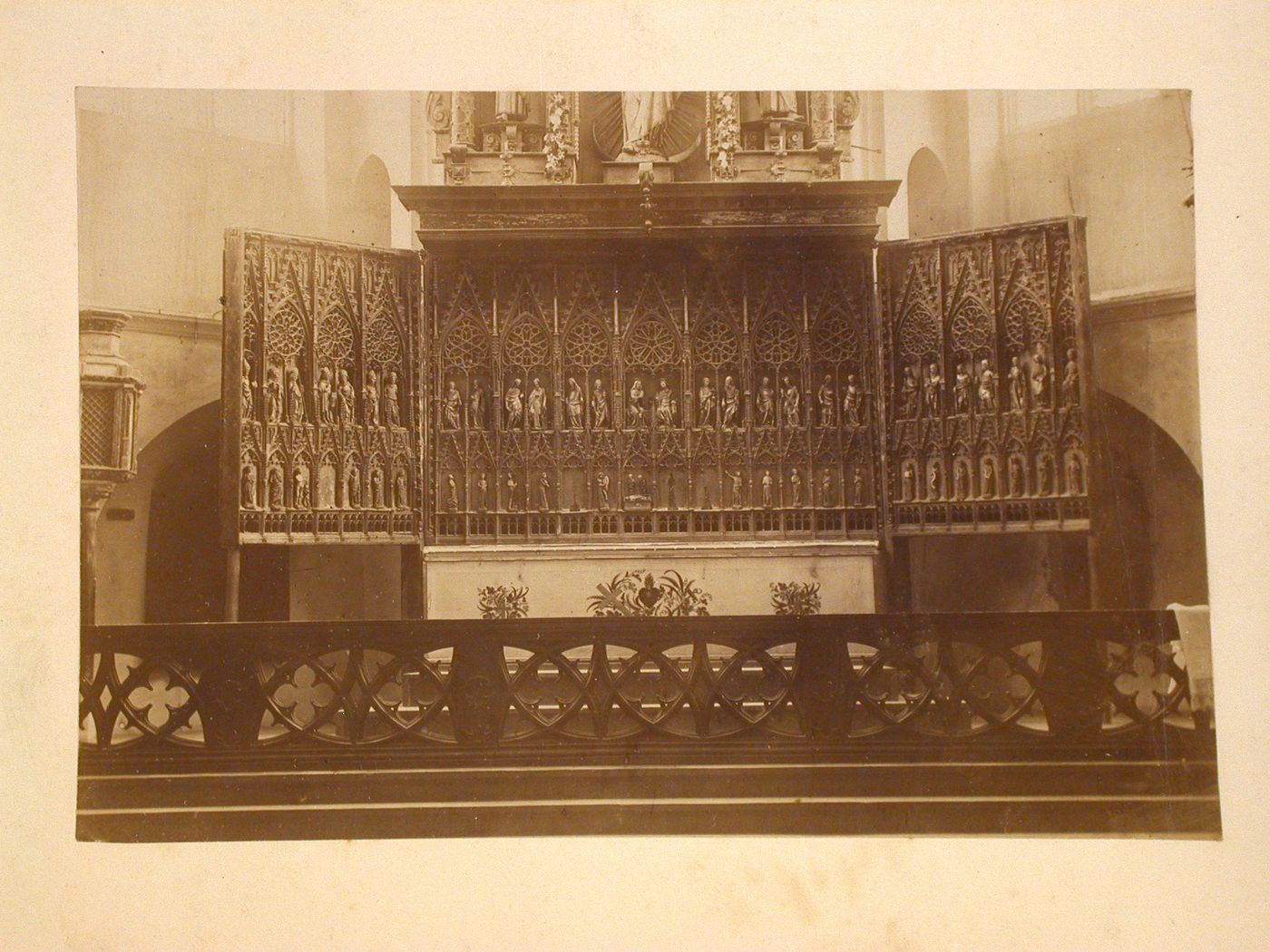 View of a triptych altarpiece behind a chancel screen, England [?]
